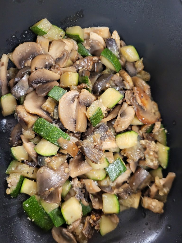 Gebakken Courgette en Champignons in een zwarte pan, vers en zonder zout, onderdeel van een ketogeen diner